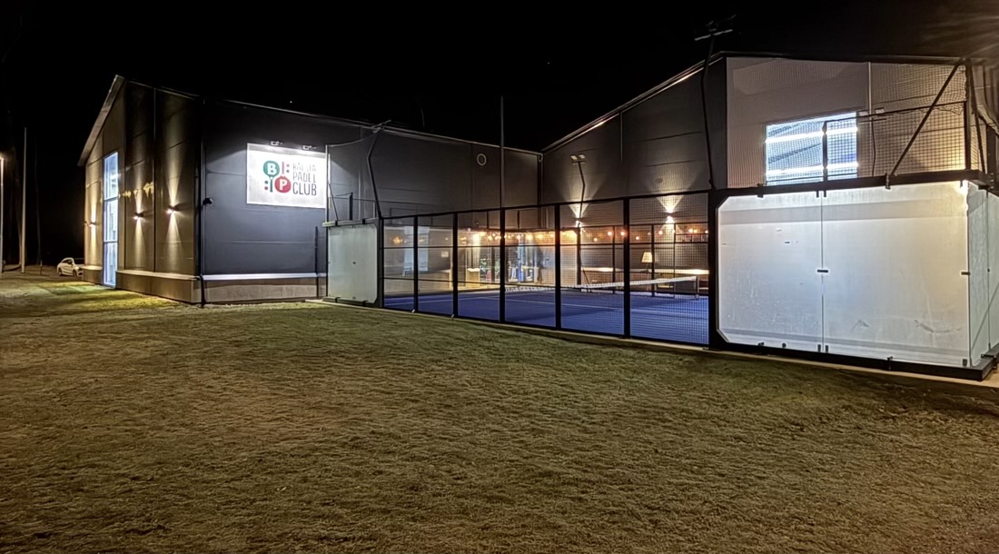 Bålsta Padel Clubs hall och utebana i kvällsljus