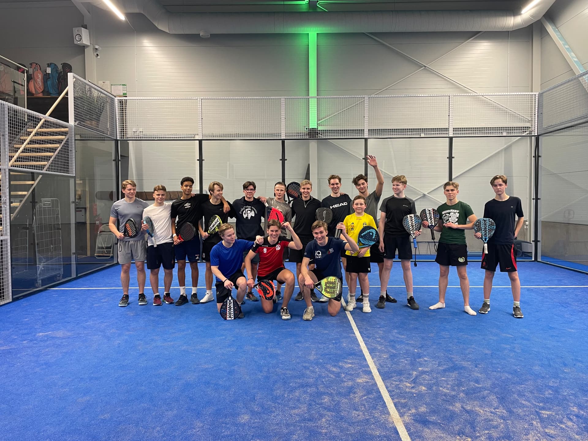 Ungdomsspelare samlade med sina racketar på padelbanan